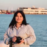 Фотографът Александра Середа с фотоапарат край морето